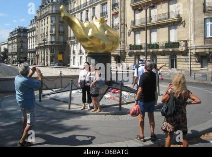 Tourists stand at the flame sculpture at the enntrance to the Pont de l'Alma tunnel, where Princess Diana died in a car accident on 31 August 1997, in Paris, France, 23 August 2012. The replica of the flame of the Statue of Liberty will be used as the location for the commemration of Diana. Photo: Benjamin Wehrmann Stock Photo