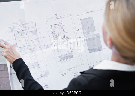 Businesswoman reading blueprints Stock Photo