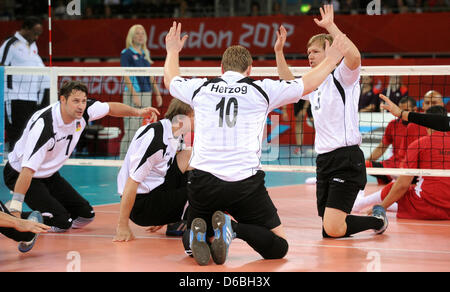Heiko Wiesenthal (l-r), Alexander Schiffler, Christoph Herzog and Stefan Haehnlein of Germany celebrate after winning the Preliminary Round Pool A match Germany vs Morocco of Men's Sitting Volleyball event in ExCel Centre during the London 2012 Paralympic Games, London, Great Britain, 31 August 2012. Photo: Julian Stratenschulte dpa  +++(c) dpa - Bildfunk+++ Stock Photo