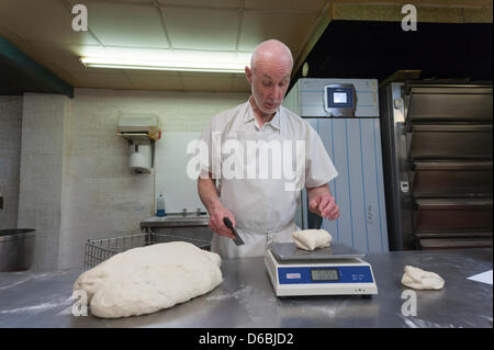 baker weighing bread dough on scale at bakery Stock Photo - Alamy