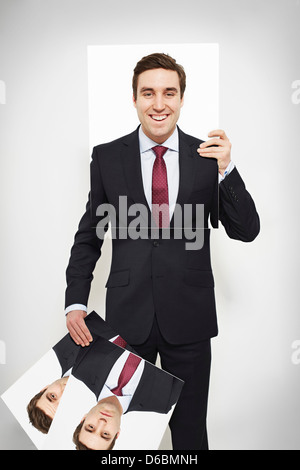 Businessman holding happy picture over his face Stock Photo
