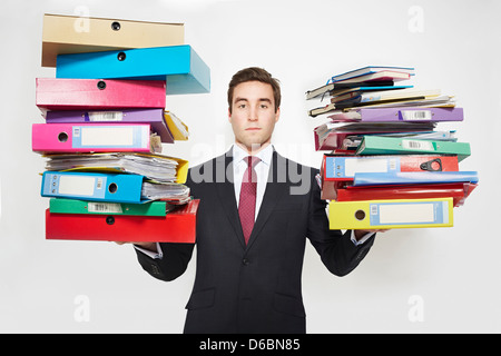 Businessman balancing stacks of folders Stock Photo