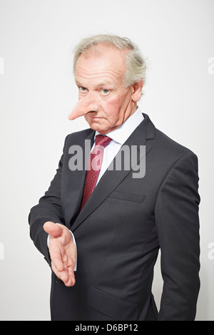 Businessman with long nose offering hand Stock Photo
