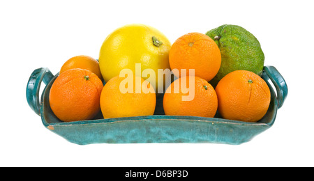 An old ceramic tray filled with uniq, pomelo, and oranges on a white background. Stock Photo