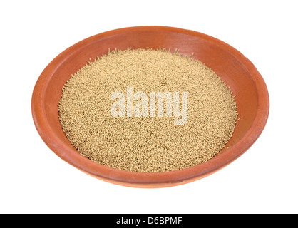 A small portion of organic active dry yeast in a red clay dish on a white background. Stock Photo