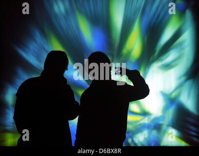 (FILE) An archive photo dated 27 September 2011 shows Japanese artist Kanjo Take talking to a visitor in front of his projection of a water fountain at the spa park in Bad Rothenfelde. The projection shows a manga hero flying through a screen of water. The projection biennial 'lichtsicht' has become a visitor magnate with more than 160,000 visitors since the beginning of October, a Stock Photo