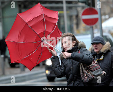 A woman fights against hurricane-force winds with her umbrella in the city centre of Frankfurt Main, Germany, 05 January 2012. With wind speeds of more than 110 km per hour storm front 'Andrea' causes trouble in Germany. Photo: Boris Roessler Stock Photo