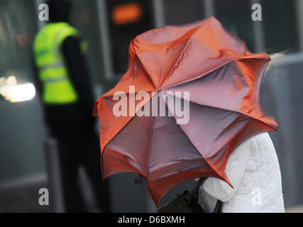 A woman fights against hurricane-force winds with her umbrella in the city centre of Frankfurt Main, Germany, 05 January 2012. With wind speeds of more than 110 km per hour storm front 'Andrea' causes trouble in Germany. Photo: EMILY WABITSCH Stock Photo