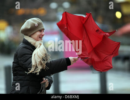 A woman fights against hurricane-force winds with her umbrella in the city centre of Frankfurt Main, Germany, 05 January 2012. With wind speeds of more than 110 km per hour storm front 'Andrea' causes trouble in Germany. Photo: EMILY WABITSCH Stock Photo