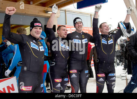 Bob pilot Maximilian Arndt (L-R) and his pushers Martin Putze, Marko Huebenbecker, and Alexander Roediger (Germany) celebrate their victory after the second competition run of the four-man bob event at the bobsled World Cup in Altenberg, Germany, 08 January 2012. Again, the bob athletes finished in first place. Photo: ARNO BURGI Stock Photo