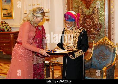 Dutch Princess Maxima (L) receives a present from Sultan Qaboos bin Said, Sultan of Oman (R) while Dutch Queen Beatrix (hidden) looks on during a state banquet at Al Alam Palace in Muscat, Oman, on 10 January 2012. The Dutch Royals are on a three-day State visit to Oman. Photo: Bernard Rubsamen/POOL / NETHERLANDS OUT Stock Photo