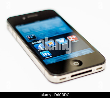 Apple iPhone on white background showing a selection of social media applications - Facebook, Twitter, Google+, LinkedIn. Stock Photo