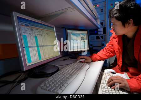 Mud logging geologist in mud log control room viewing results from onshore oil and gas exploration rig site Iraqi Kurdistan Iraq Stock Photo