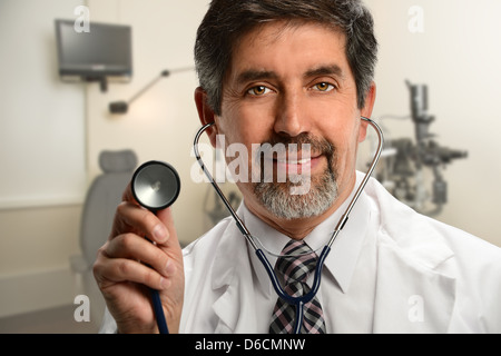 Portrait of Hispanic doctor using stethoscope in office Stock Photo