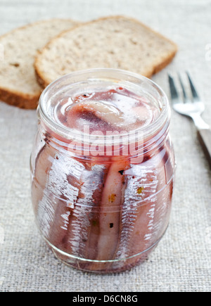 Traditional pickled herring in a jar with ingredients close-up on the ...