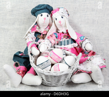 Two Easter Handmade Bunnies with Decorated Eggs in Basket Stock Photo