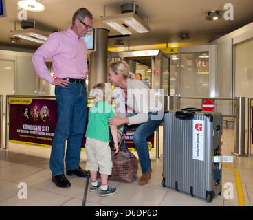 Former German President Christian Wulff (L) and his son Linus welcome wife and mother Bettina at the airport in Hanover, Germany, 10 September 2012. Bettina Wulff visited the Paralympics in London. Bettina Wulff's book 'Jenseits des Protokolls' is available in stores now. Photo: Jochen Luebke Stock Photo