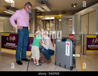 Former German President Christian Wulff (L) and his son Linus welcome wife and mother Bettina at the airport in Hanover, Germany, 10 September 2012. Bettina Wulff visited the Paralympics in London. Bettina Wulff's book 'Jenseits des Protokolls' is available in stores now. Photo: Jochen Luebke Stock Photo