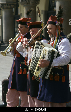 Musician buskers dressed in Polish national costume in the Old City of Krakow Poland Stock Photo