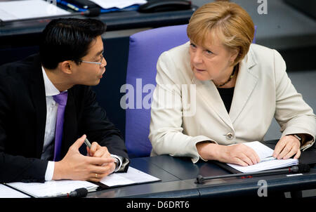 German Chancellor Angela Merkel (CDU) talks to German Minister of Economics Philipp Roesler (FDP) at the Bundestag in Berlin, Germany, 12 September 2012. The German parliament will deliberate on next year's federal budget. Photo: KAY NIETFELD Stock Photo