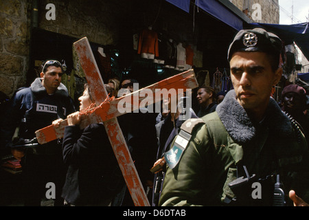 Members of the Israeli Security Forces stand guard as Christian pilgrims reenact the Passion of Christ along Via Dolorosa during a Good Friday procession in the old city of Jerusalem Israel Stock Photo