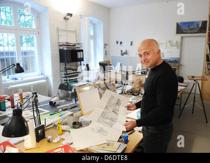dpa-Exclusive: The artist and architect Yadegar Asisi holds a graphic blueprint of his latest project, the Berlin Wall panorama, in his studio in the Kreuzberg neighbourhood in Berlin, Germany, 12 September 2012. The creator of the Berlin Wall panorama ,Vienna-born artist and architect Yadegar Asisi, used to live near the Berlin Wall in the Kreuzberg neighbourhood of Berlin in the  Stock Photo