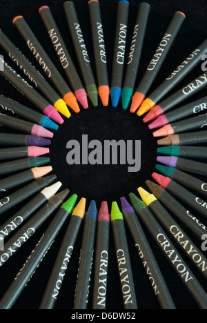 Close up on a circle created in the center of a circle of colorful children's crayons, isolated on a black background Stock Photo