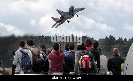 Visitors watch a flight demonstration of an Mikoyan MiG-29 fighter jet from the Polish air force completes an acceptance flight on the first public day of the Berlin Air Show (ILA) held from Schoenefeld Airport in Berlin, Germany, 15 September 2012. The aviation trade show south of Berlin takes place from 11 till 16 September 2012.  Photo: WOLFGANG KUMM Stock Photo