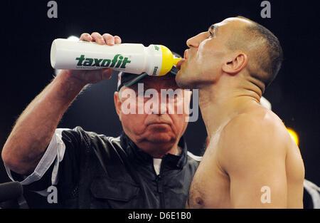 Coach Ulli Wegner gives German boxer Arthur Abraham something to drink during the WBO Europe super-middleweight Championship fight between Abraham and Argetnine boxer Farias. Abraham won the fight at the Baden Arena in Offenburg, Germany, 14 January 2012. Photo: Patrick Seeger Stock Photo