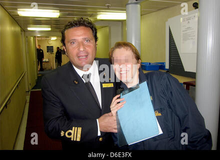 (FILE) An archive photo dated 22 June 2011 shows Franscesco Schettino, captain of the 'Costa Concordia', posing with a crew member onboard the sister ship 'Costa Atlantica' for a passenger during a Norweigian cruise in Gerianger Fjord, Norway. The captian of the capsized cruise ship off the Giglio island had a detention hearing lasting several hours on Tuesday 17 January 2012. He i