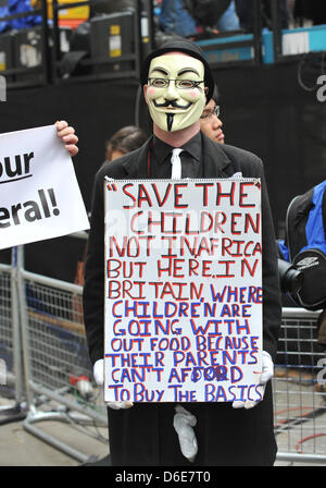 St paul's Cathedral, London, UK. 17th April 2013. A protester wearing an anonymous mask holds a placard before the start of the procession outside St Paul's Cathedral. The funeral procession of Baroness thatcher takes place along the streets of central London. Credit: Matthew Chattle/Alamy Live News Stock Photo