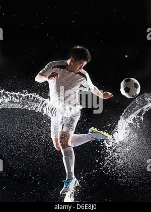 Asian soccer player splashing in water
