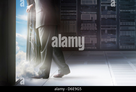 Caucasian businessman walking into clouds Stock Photo