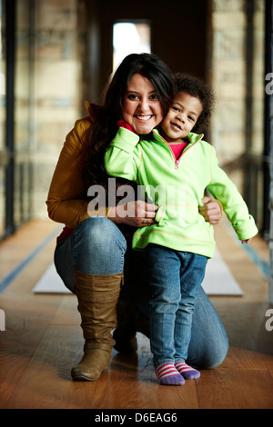 Mother and daughter smiling in hallway Stock Photo