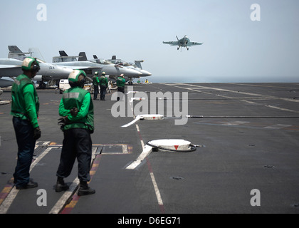 A US Navy F/A-18E Super Hornet fighter aircraft comes in to land aboard the aircraft carrier USS Dwight D. Eisenhower April 11, 2013 in the North Arabian Sea. The Eisenhower is deployed to the 5th Fleet supporting operations in Afghanistan. Stock Photo