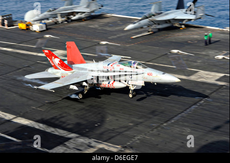 A US Navy F/A-18E Super Hornet fighter aircraft lands aboard the aircraft carrier USS Dwight D. Eisenhower April 11, 2013 in the North Arabian Sea. The Eisenhower is deployed to the 5th Fleet supporting operations in Afghanistan. Stock Photo