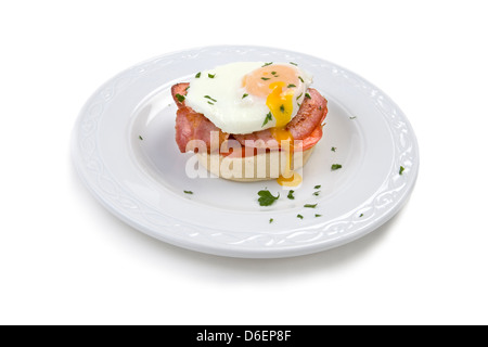 Soft poached egg on muffin with bacon and tomato Stock Photo