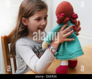Young Girl Holding Soft Knitted Doll England Stock Photo