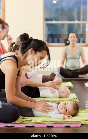 Mothers and babies taking yoga class Stock Photo