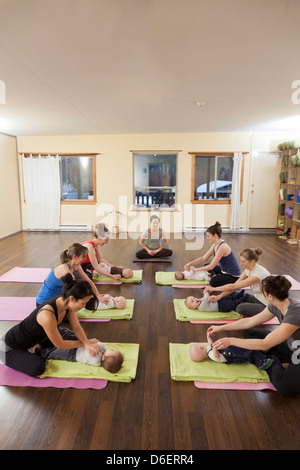 Mothers and babies taking yoga class Stock Photo