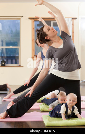 Mothers and babies taking yoga class Stock Photo