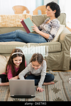 Mother and daughters relaxing in living room Stock Photo