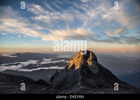First rays of the rising sun on St John's Peak from the summit of Gunung Kinabalu Borneo one of the highest mountains in SE Asia Stock Photo