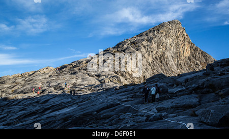 Low's Peak is the highest summit on Gunung Kinabalu Borneo here given scale by figures of climbers on its slopes Stock Photo