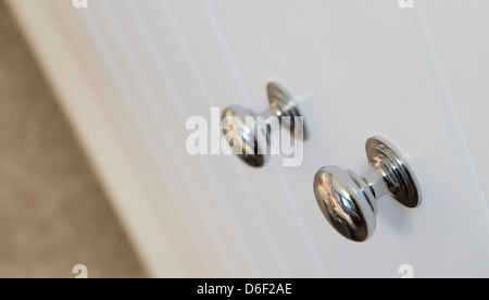 Close up of chrome knobs on a cupboard door. Stock Photo