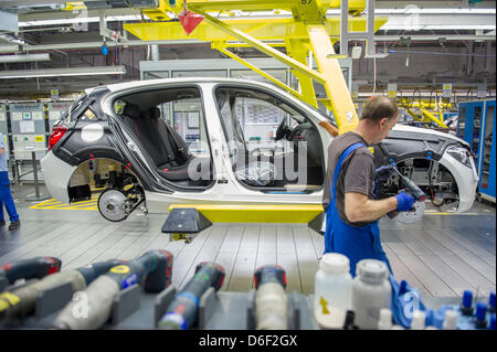 An employee of car manufacturer BMW works on a car at the BMW factory in Regensburg, Germany, 10 April 2013. Photo: Marc Mueller Stock Photo