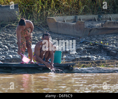 A young man and woman washing in the Kinabatangan River in Sabah Borneo early in the morning Stock Photo