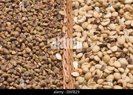 Several types of nuts with salt in wicker baskets. Focus on center of the image. Stock Photo