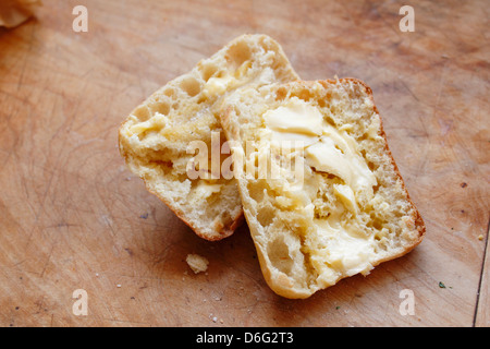 Warm Ciabatta bread  with butter on chopping board Stock Photo