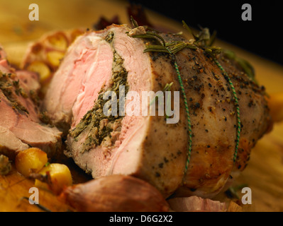 Sliced leg of stuffed lamb with garlic, rosemary and roast onion Stock Photo